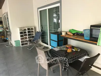 Spacious balcony with seating area and storage, perfect for relaxation.