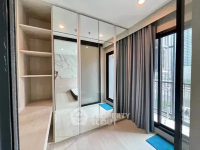 Modern bedroom with mirrored wardrobe and city view balcony access.
