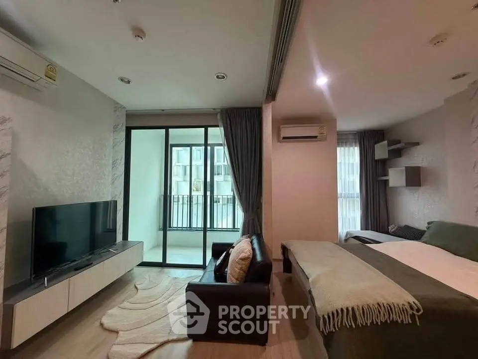 Modern studio apartment with cozy living area and balcony view