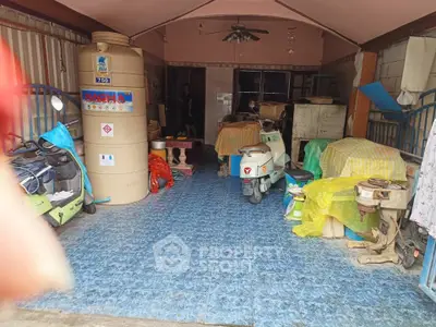 Spacious garage with scooters and storage items, featuring blue tiled flooring and ample space for organization.