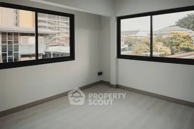 Spacious and well-lit corner unit with large windows offering an urban view, perfect for creating a personalized living space.