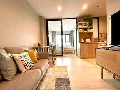 Modern living room with cozy sofa and open view to bedroom