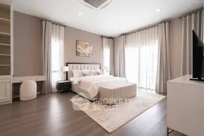 Luxurious master bedroom with elegant decor and ample natural light, featuring a plush bed and stylish furnishings.