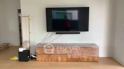 Modern living room with wall-mounted TV and sleek wooden cabinet