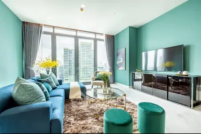 Luxurious living room with stunning city view, modern decor, and plush furnishings in high-rise apartment.