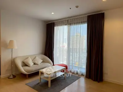 Modern living room with cozy sofa and city view through large windows.