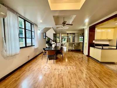 Spacious open-plan living area with wooden flooring and modern kitchen.