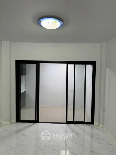 Modern interior with sliding glass doors and stylish ceiling light fixture.