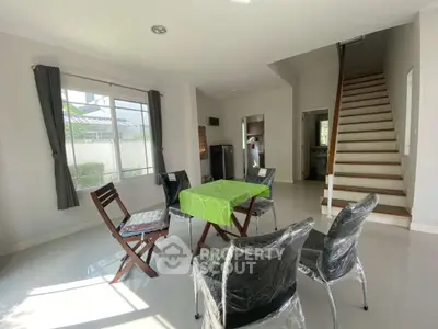 Bright and airy living room with modern furniture and staircase, perfect for family gatherings.
