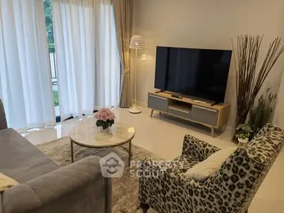 Elegant living room with modern decor, large TV, and natural light from floor-to-ceiling windows.