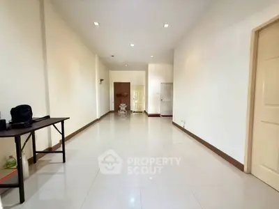 Spacious and bright living room with sleek tile flooring and modern design.