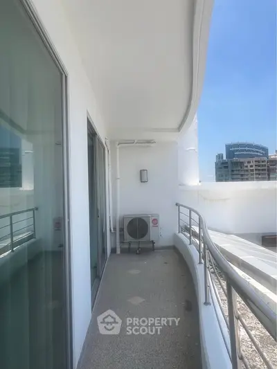 Spacious balcony with modern railing and city view, perfect for relaxation and outdoor enjoyment.