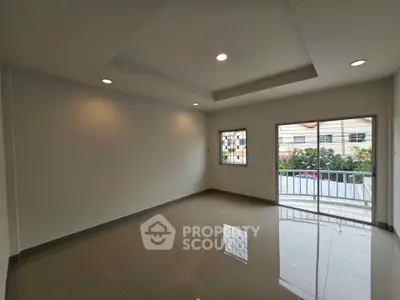 Spacious empty room with large window and balcony access, perfect for customization.