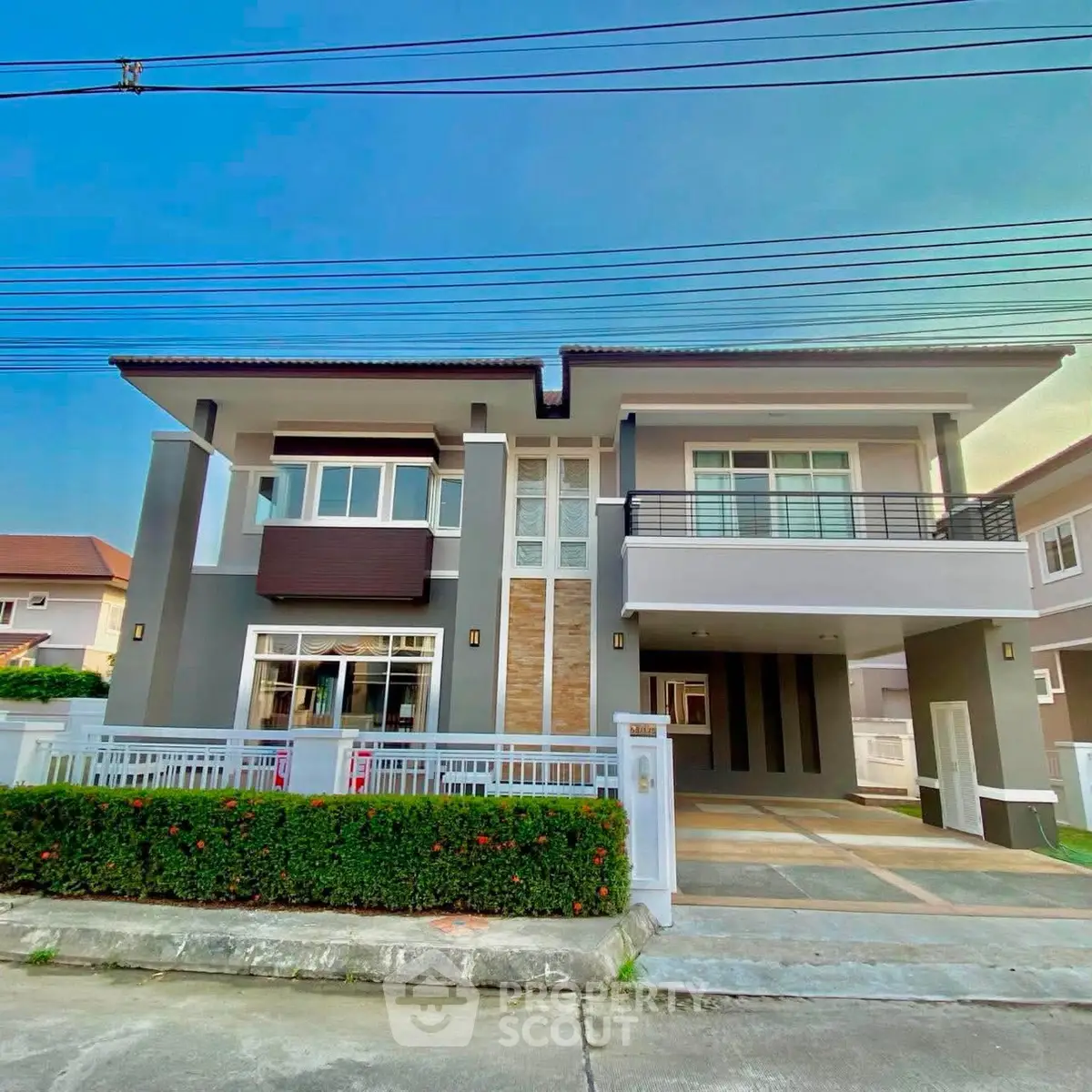 Modern two-story house with sleek design and spacious driveway in a suburban neighborhood.
