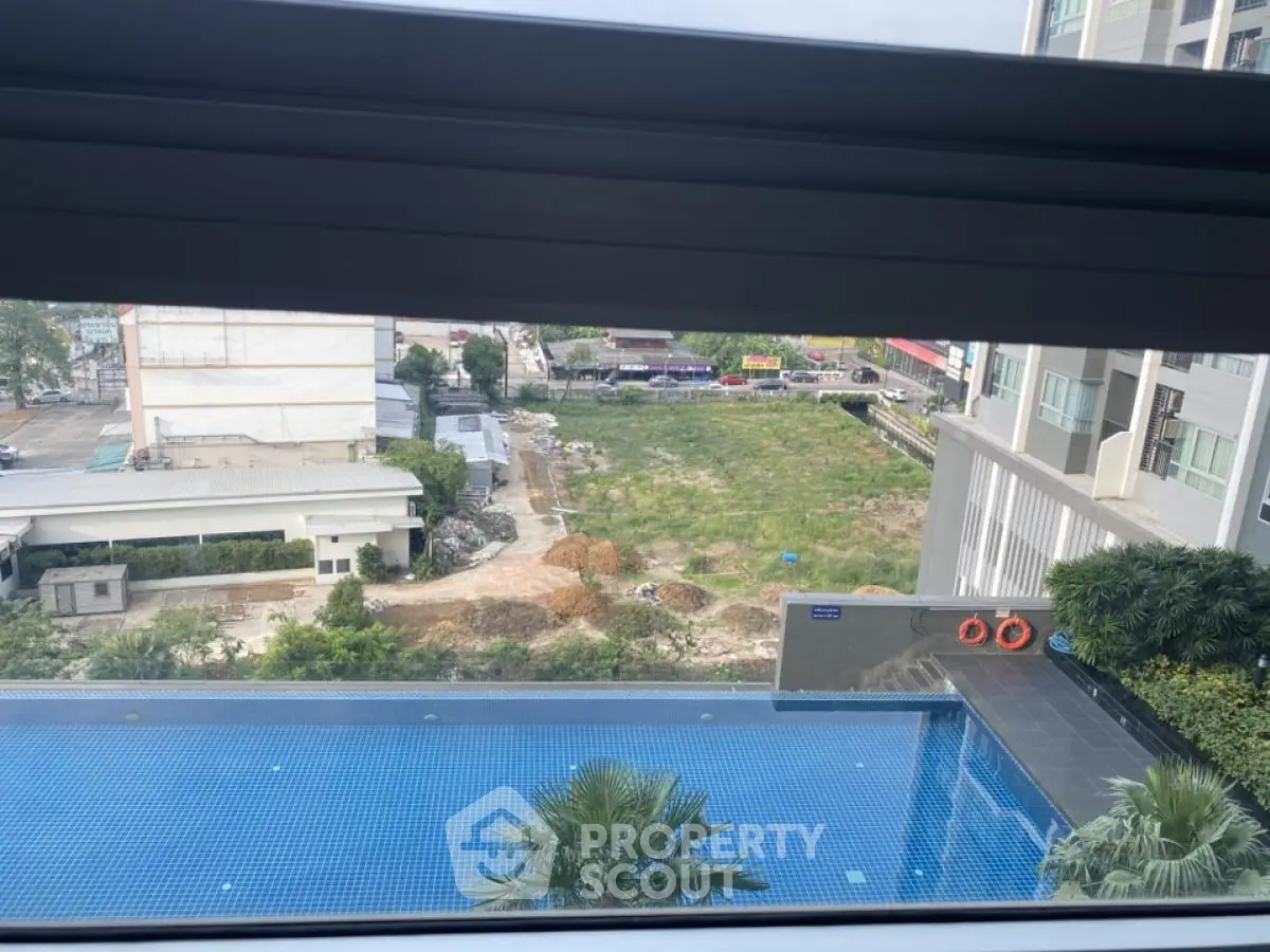 Stunning view from high-rise apartment overlooking pool and lush garden area.