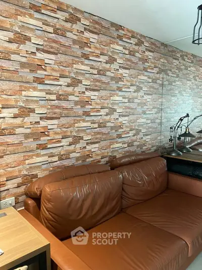 Stylish living room with brown leather sofa and modern stone accent wall