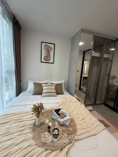 Cozy bedroom with stylish decor and large window offering natural light