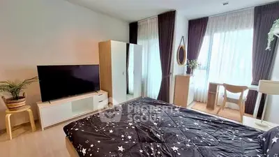 Modern bedroom with stylish decor, large TV, and natural light from floor-to-ceiling windows.