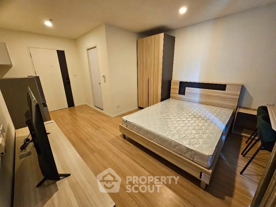 Modern bedroom with wooden flooring and stylish furniture in a cozy apartment.