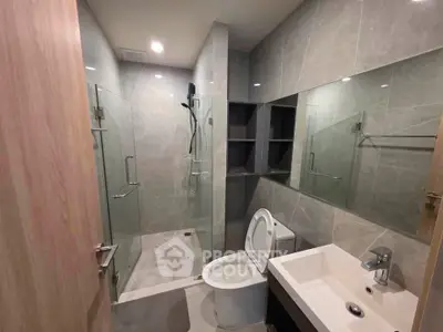 Modern bathroom with glass shower and sleek fixtures in a contemporary apartment.