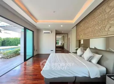 Luxurious bedroom with pool view and elegant wooden flooring