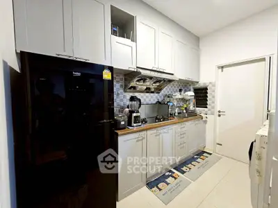 Modern kitchen with sleek cabinets and appliances, featuring a closed layout and stylish backsplash.