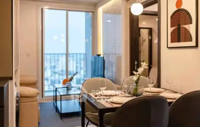 Modern dining area with elegant decor and large window view in stylish apartment.
