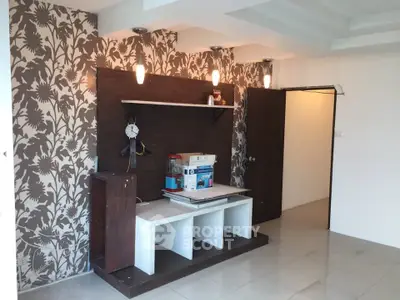 Stylish living room with modern wallpaper and built-in shelving unit.