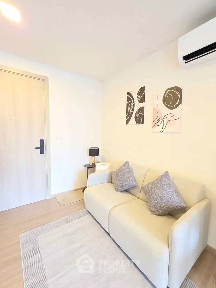 Cozy living room with modern decor and air conditioning, perfect for relaxation.