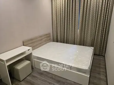 Modern bedroom with minimalist design, featuring a bed and a small desk with stool.