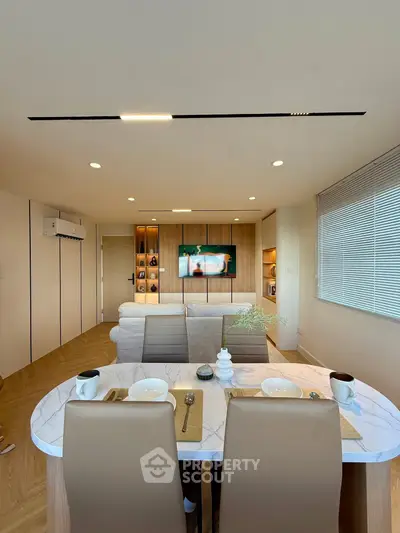 Modern living room with dining area, featuring sleek furniture and stylish decor, perfect for contemporary living.