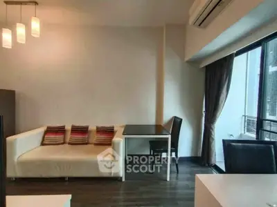 Modern living room with stylish sofa and dining area, featuring elegant lighting and large windows.