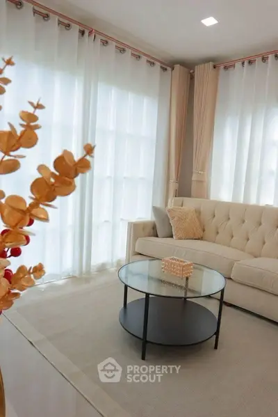 Elegant living room with plush sofa and round glass coffee table