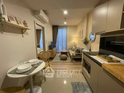 Modern open-layout kitchen and living room with stylish decor and natural lighting.