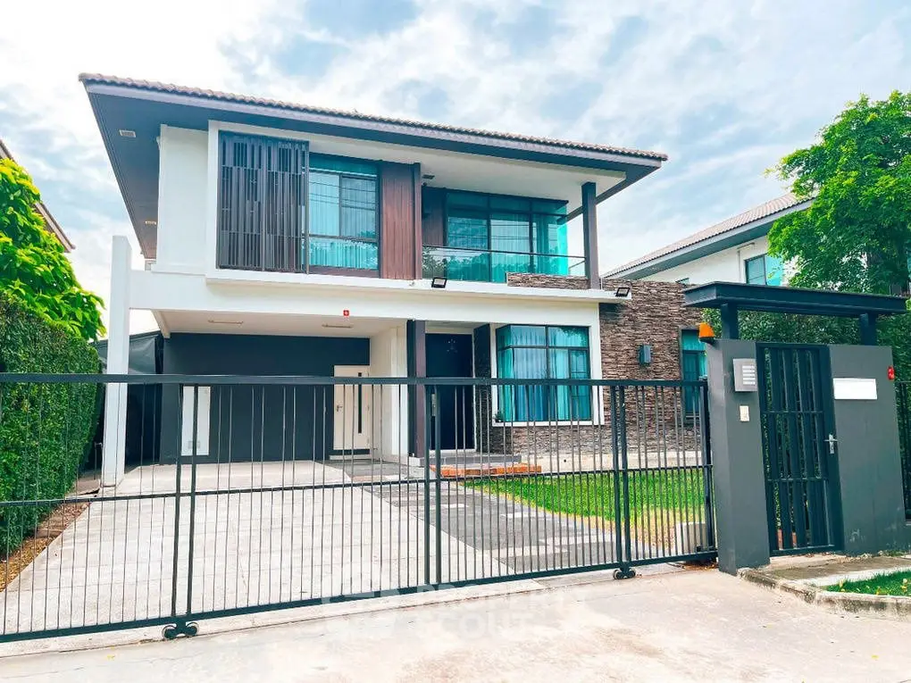 Modern two-story house with sleek design and spacious driveway in a serene neighborhood.