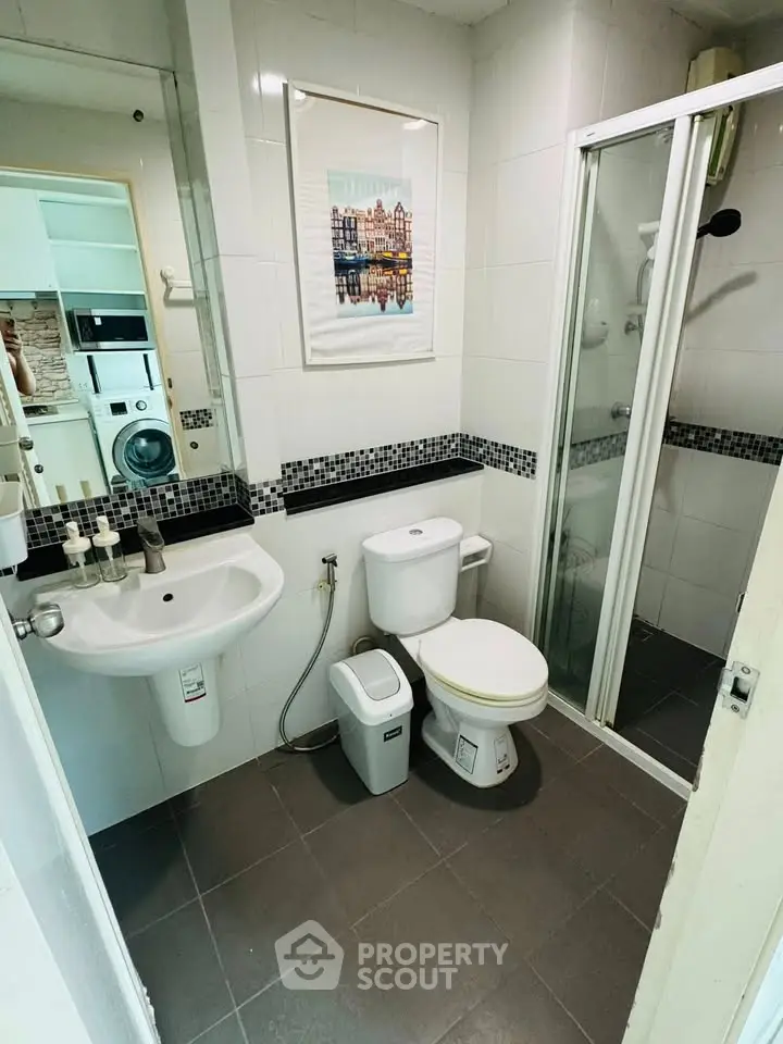 Modern bathroom with shower and washing machine in compact layout