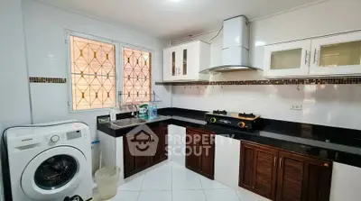 Spacious kitchen with modern appliances and gas stove, featuring ample storage and natural light.