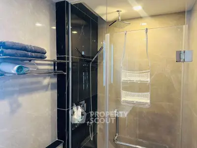 Luxurious modern bathroom with sleek glass shower and elegant tile design.