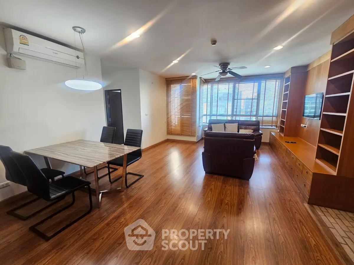 Spacious living room with modern furniture and wooden flooring in a stylish apartment.
