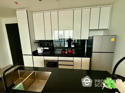 Modern kitchen with sleek cabinetry and stainless steel appliances in a contemporary apartment.