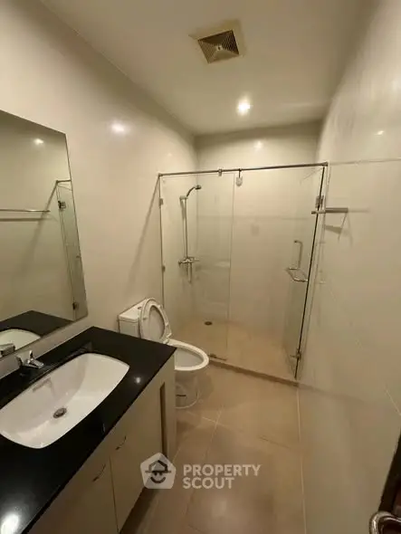 Modern bathroom with glass shower and sleek fixtures in a contemporary home.