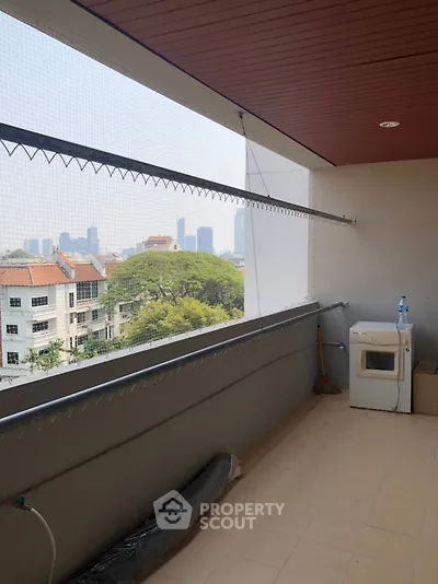 Spacious balcony with city view and laundry area in modern apartment