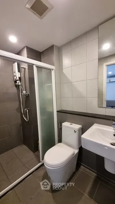 Modern bathroom with shower and sleek fixtures in contemporary apartment.