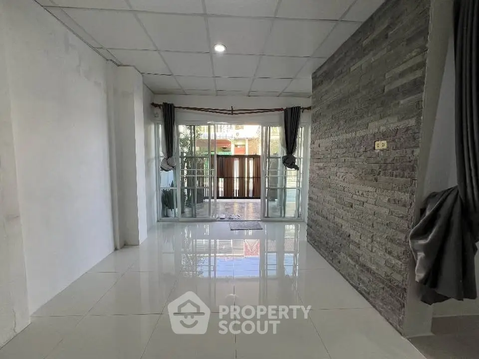 Spacious modern living room with large windows and tiled flooring