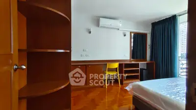 Spacious bedroom with modern furnishings and balcony access in a high-rise apartment.