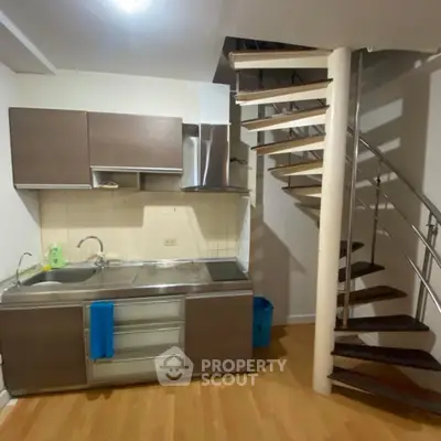 Modern kitchen with sleek cabinetry and spiral staircase, perfect for urban living.