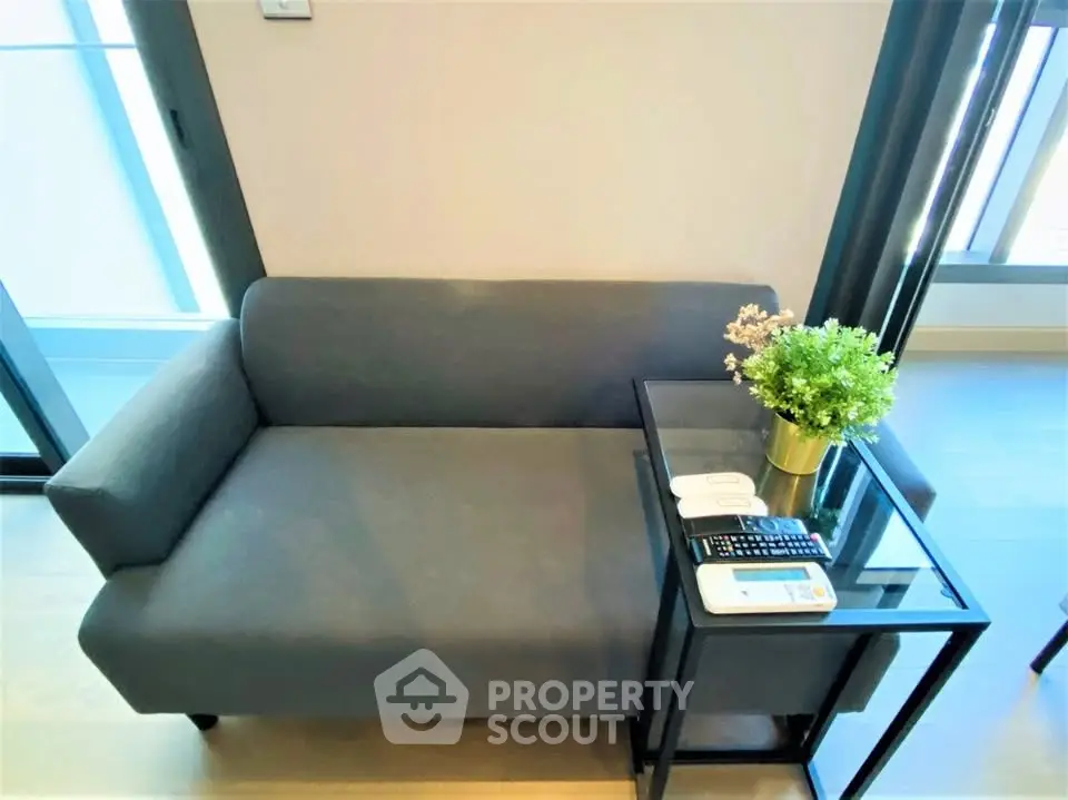 Modern living room with sleek gray sofa and glass side table, perfect for urban living.