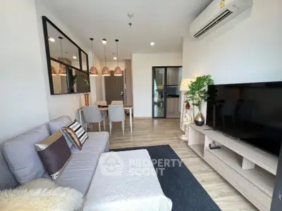 Modern living room with stylish decor, cozy seating, and open dining area in a contemporary apartment.