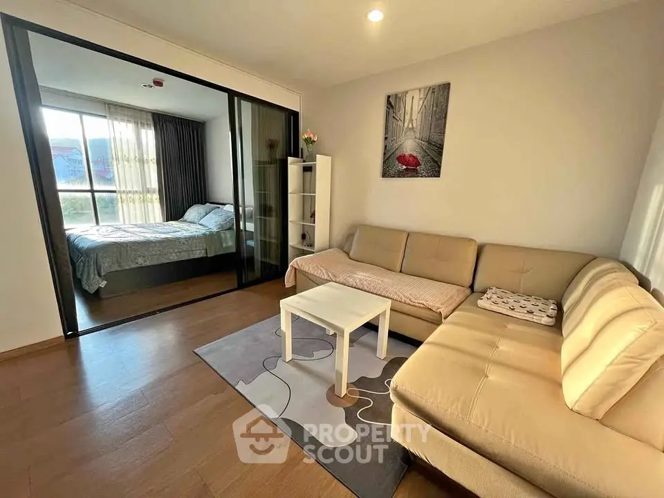 Modern living room with cozy sofa and adjoining bedroom