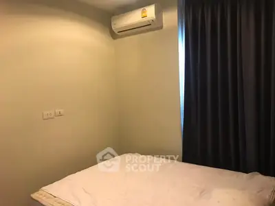 Cozy bedroom with air conditioning and dark curtains for a restful ambiance.